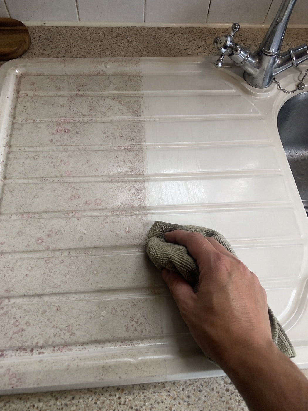 Stained plastic draining board wiped back to white.