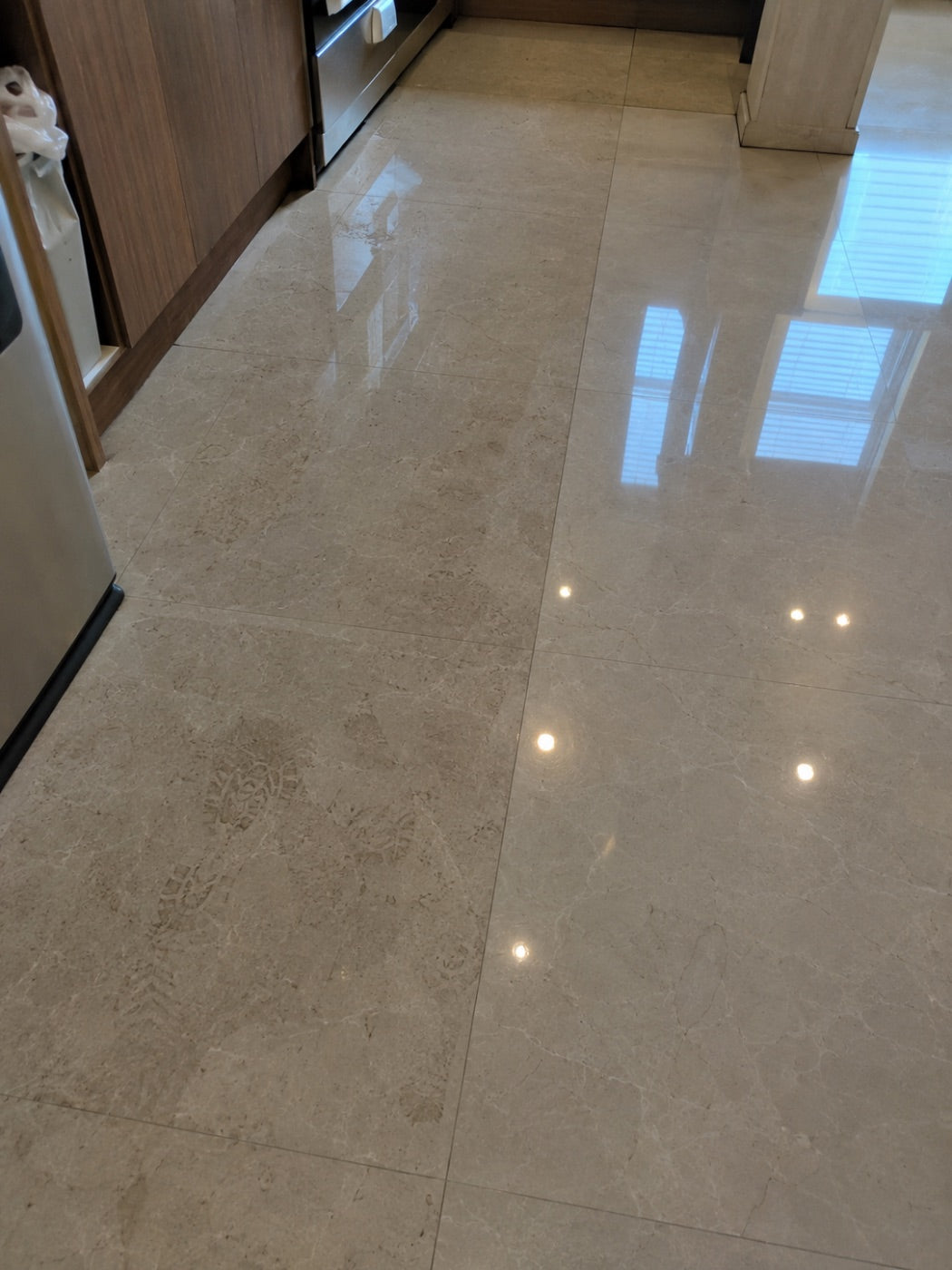 Polished stone kitchen floor cleaned to a reflective finish.