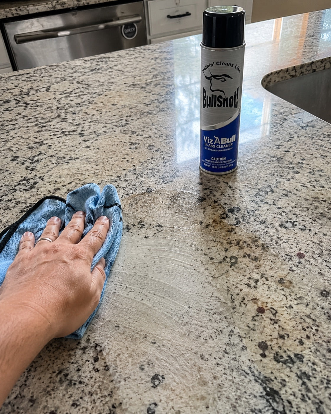 Granite worktop being wiped streak-free with VizABull beside it.